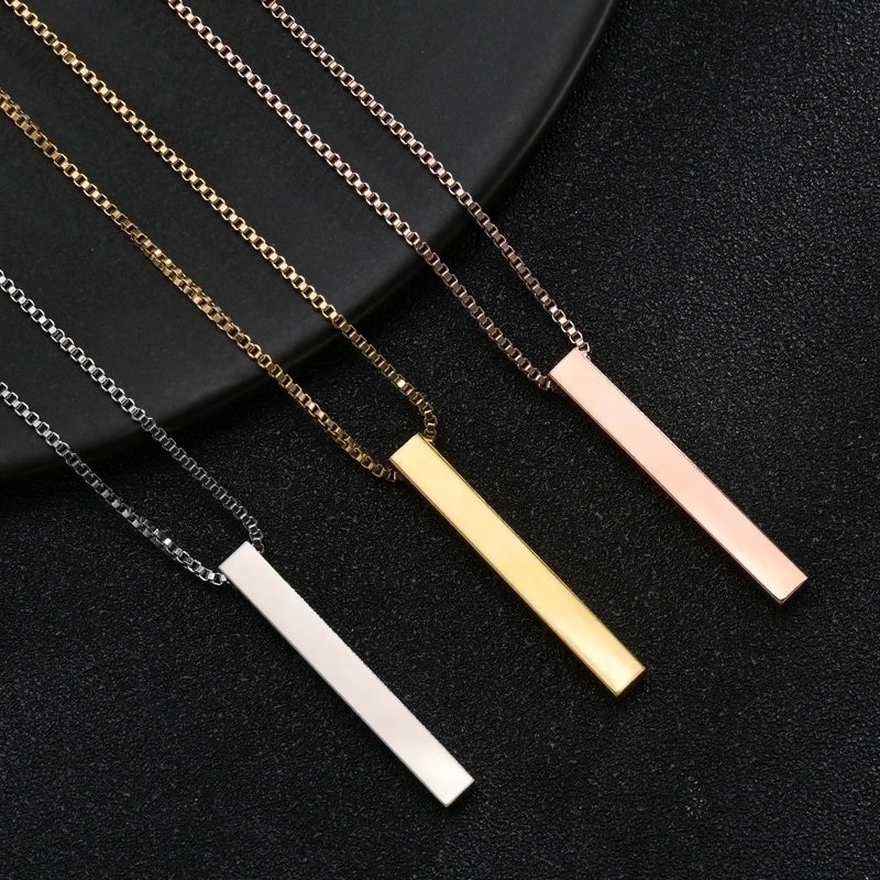 Three necklaces with bar pendants in gold, silver, and rose gold on a black background